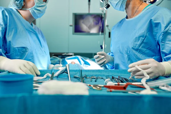 Un equipo de cirujanos uniformados realiza una operación a un paciente en una clínica de cirugía cardíaca. Medicina moderna, un equipo profesional de cirujanos, salud . — Foto de Stock