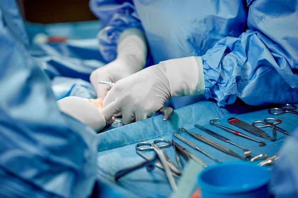 Instrumentos e instrumentos quirúrgicos, incluyendo bisturíes, fórceps y fórceps, ubicados sobre la mesa para cirugía. Medicina, cirugía, salvar vidas . — Foto de Stock