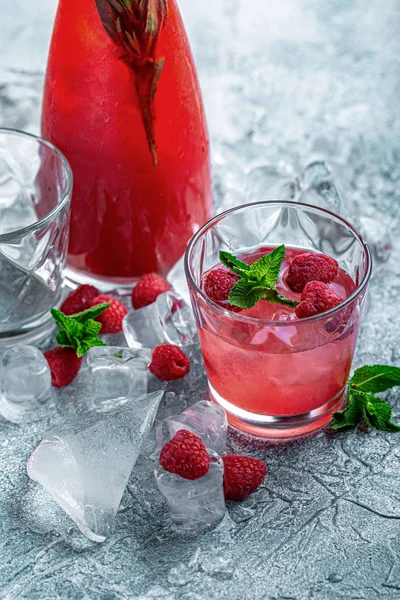 Raspberry cocktail, fizz, lemonade, ice tea with fresh mint on blue wooden background. Close up. — Stock Photo, Image