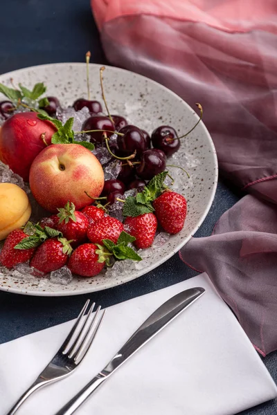 Здорові фруктові тарілки, полуниці, яблука, персики, абрикоси на темно-сірому дерев'яному столі, вид зверху, крупним планом, вибірковий фокус . — стокове фото