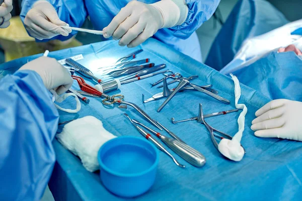 Chirurgische Instrumente und Instrumente, einschließlich Skalpelle, Pinzetten und Pinzetten, die sich auf dem Operationstisch befinden. Medizin, Chirurgie, Rettung von Leben. — Stockfoto