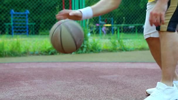 Baloncesto en la calle, entrenamiento para hacer malabares con una pelota para el baloncesto. El concepto de deporte, entrenamiento, entrenamiento en la calle, auto-motivación, disciplina, alcanzar el éxito. Primer plano . — Vídeo de stock