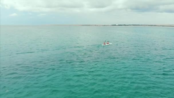 푸른 바다에서 카약, 극단적 인, 활동적인 여행. 카약을 타는 사람들은 푸른 바다에서 수영을 합니다. 드론으로 상단 을 촬영. — 비디오