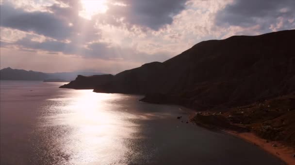 산과 바다의 아름다운 파노라마 전망, 위에서 촬영. 흐린 날에 해안선에서 공중 촬영, 태양 광선은 구름, 아름다운 빛을 통해 자신의 길을 확인 — 비디오