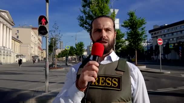 Repórter profissional vive na rua da cidade. Um repórter com roupas especiais caminha pelas ruas da cidade, escolhe locais para filmar . — Vídeo de Stock