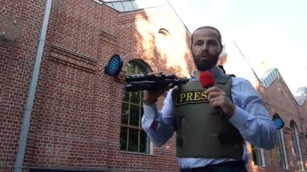 Professionele reporter Live in City Street. Een reporter met speciale kleren wandelingen door de straten van de stad, kiest locaties voor het filmen. — Stockvideo