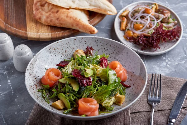 Lachssalat mit Spinat, Maissalat, Babyspinat, frischer Minze und Basilikum. Hausgemachtes Essen. Konzept für eine schmackhafte und gesunde Mahlzeit. Dunkler Steinhintergrund. Ansicht von oben. Nahaufnahme. — Stockfoto