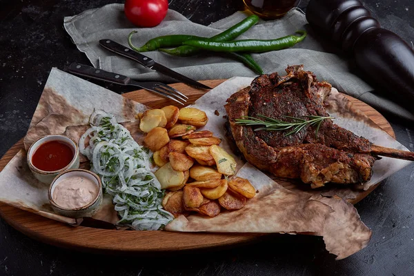 Томахок стейк с овощами и ножом на столе. Мясо на гриле с овощами и свежими овощами на столе . — стоковое фото