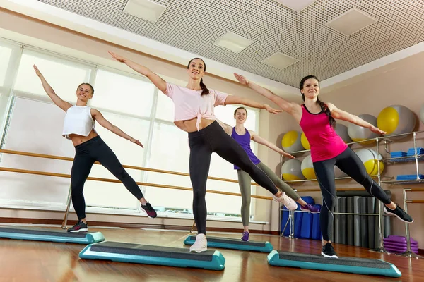 Grupa młodych, atrakcyjnych sportowców ćwiczących lekcję jogi z instruktorem, stojących razem w ćwiczeniach, ćwiczących, na całej długości, tło studyjne, zbliżenie — Zdjęcie stockowe
