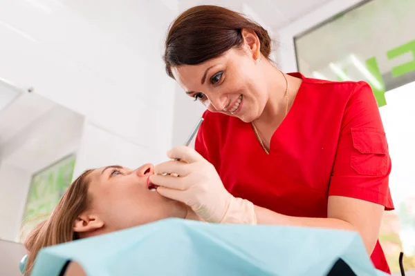 Een vrouwelijke tandarts die haar patiënt controleert op cariës. Het meisje zal zorgen voor de gezondheid van de tanden. Mooie, gezonde tanden, tanden verzorging. — Stockfoto
