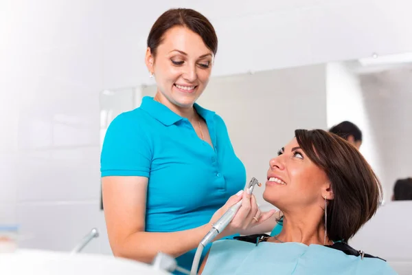 Una dentista che controlla la carie della paziente. La ragazza si prenderà cura della salute dei denti. Denti belli, sani, cura dei denti . — Foto Stock