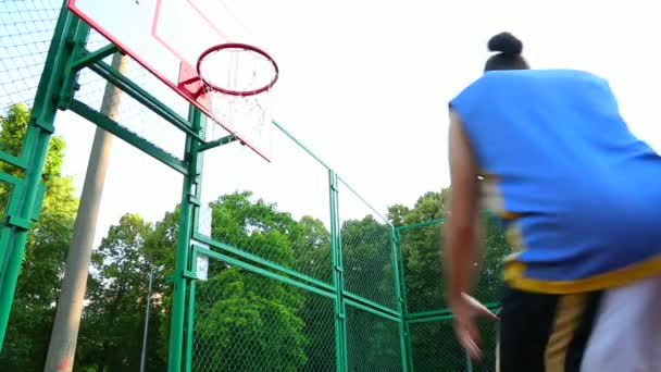 Motivação desportiva. Basquetebol de rua. O jogador marca a bola no cesto na quadra de rua. Jogo de treinamento de basquete. Esporte conceitual, motivação, realização de objetivos, estilo de vida saudável . — Vídeo de Stock