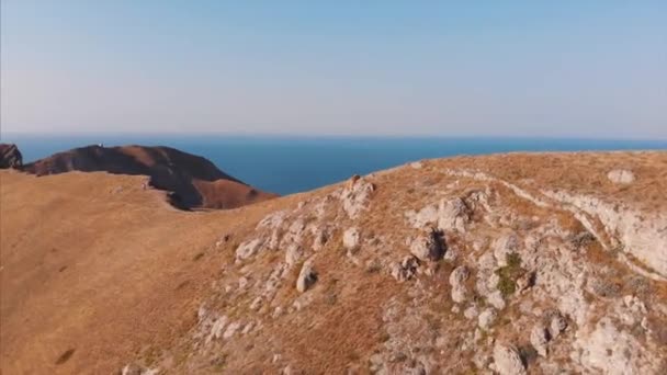 Beautiful panoramic view of the mountains and the sea, filming from above. Aerial shooting from the shoreline on a sunny day. Travel, mountains, nature, freedom concept. — Stock Video