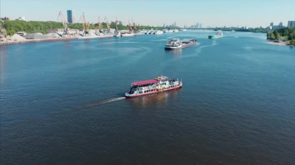 Flod kryssningsfartyg seglar på floden inom staden, mot bakgrund av det urbana landskapet. Flodtransporter, rekreation i staden, underhållning. — Stockvideo