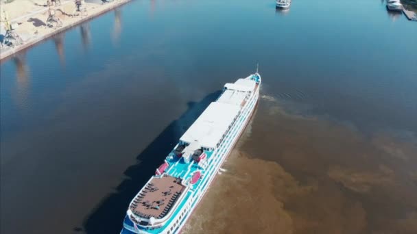 Navio de cruzeiro fluvial navega no rio dentro da cidade, no contexto da paisagem urbana. Transporte fluvial, recreação na cidade, entretenimento . — Vídeo de Stock