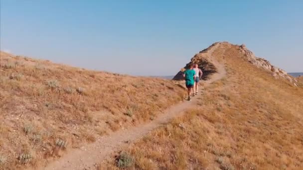 Sendero corriendo por las montañas, deportistas, haciendo ejercicio al aire libre, corriendo estilo de vida de aventura. Deporte, estilo de vida saludable, el deseo de desarrollar el logro de objetivos altos . — Vídeos de Stock