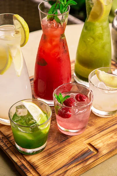 Refrescos de verano, un juego de limonadas. Limonadas en jarras sobre la mesa, cuyos ingredientes se preparan se disponen alrededor . —  Fotos de Stock