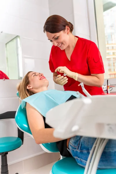 Eine Zahnärztin untersucht ihre Patientin auf Karies. Das Mädchen kümmert sich um die Gesundheit der Zähne. schöne, gesunde Zähne, Zahnpflege. — Stockfoto