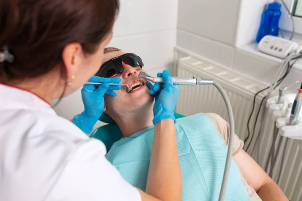 Behandlung von Karies. Ein Zahnarzt behandelt die Zähne der Patienten auf Pulpitis. Parodontitis der Zähne. — Stockfoto