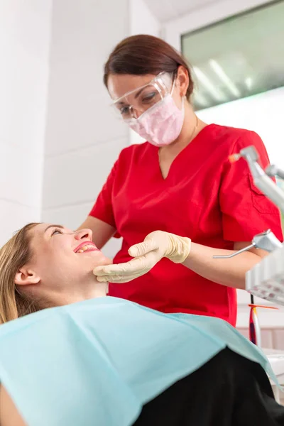 Een vrouwelijke tandarts die haar patiënt controleert op cariës. Het meisje zal zorgen voor de gezondheid van de tanden. Mooie, gezonde tanden, tanden verzorging. — Stockfoto