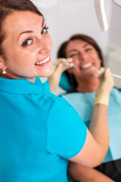 Zahnspangen für die Zähne der Frauen in der Zahnarztpraxis. Zahnarzt untersucht Patientin mit Zahnspange in Zahnarztpraxis. Nahaufnahme eines jungen attraktiven Mädchens mit Zahnspange — Stockfoto