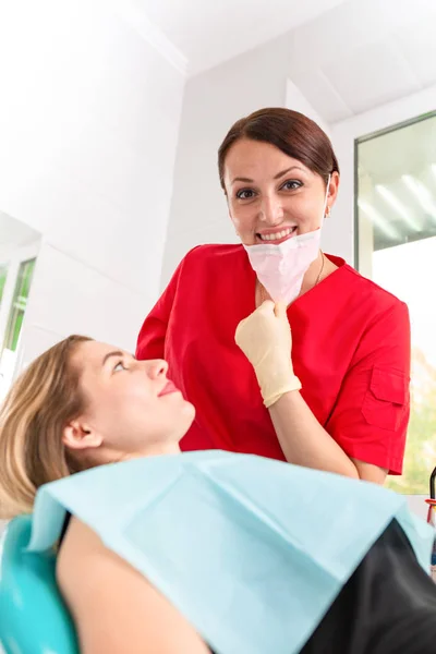 Eine Zahnärztin untersucht ihre Patientin auf Karies. Das Mädchen kümmert sich um die Gesundheit der Zähne. schöne, gesunde Zähne, Zahnpflege. Stockbild