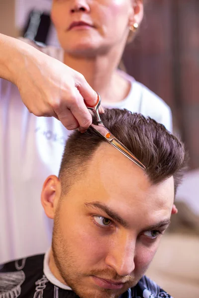 Крупный план студента мужского пола, стригущего волосы стрижкой — стоковое фото