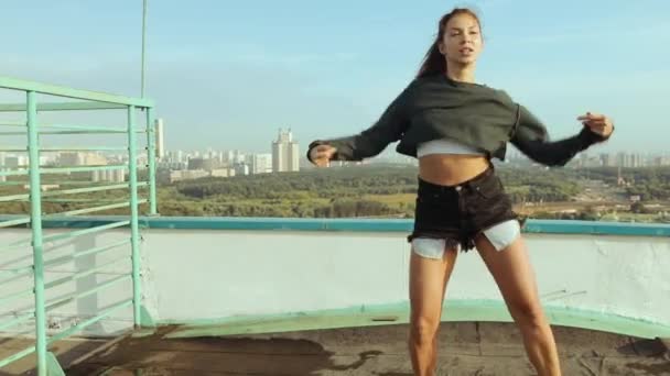 Une jeune femme séduisante danse et s'étire avec un paysage urbain sur fond de soleil levant. Liberté de choix, d'expression, de ne pas être comme tout le monde . — Video