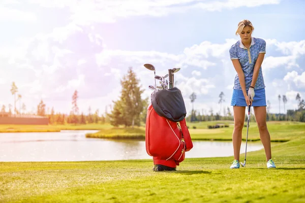 高尔夫球场上，一个漂亮的女孩准备击球。生活方式理念，高尔夫理念，追求卓越，工艺，皇家运动，体育旗帜. — 图库照片