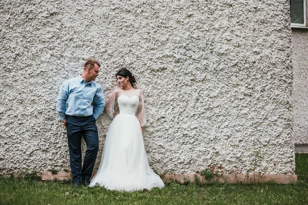 Hermosos novios abrazándose y besándose el día de su boda al aire libre. Concepto boda, nueva familia . — Foto de Stock