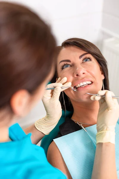 Geweldige glimlach top uitzicht van tandarts het onderzoeken van zijn mooie patiënt in tandarts s Office — Stockfoto