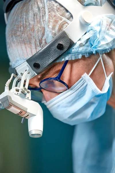 Retrato de perto de uma médica cirurgiã usando máscara protetora e chapéu durante a operação. Saúde, educação médica, conceito de cirurgia . — Fotografia de Stock