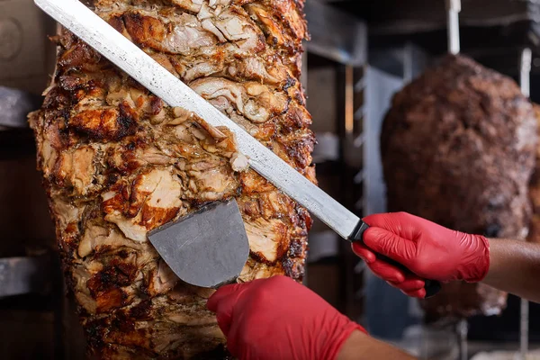 Gebratenes Fleisch am Spieß zum Kochen von Spendern oder Shawarma. Nahaufnahme Stockbild