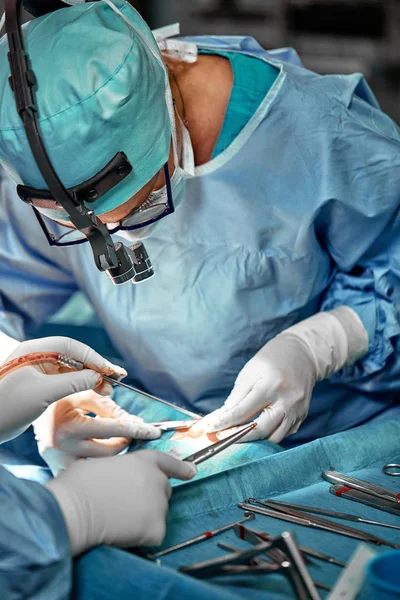 Retrato de cerca de la doctora cirujana usando máscara protectora y sombrero durante la operación. Salud, educación médica, concepto de cirugía . — Foto de Stock