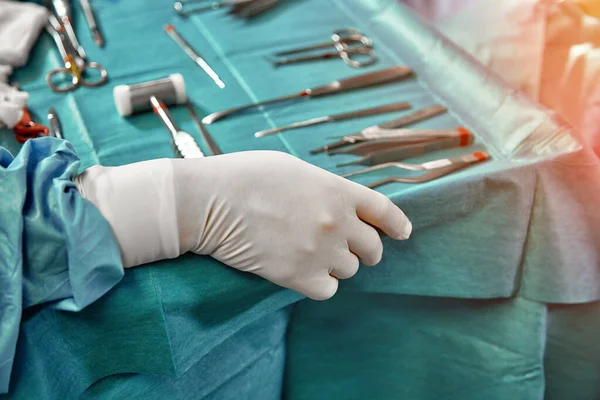 Medizinische Instrumente mit Chirurgen Hand in Hand im Operationssaal — Stockfoto