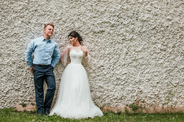 Hermosa pareja de boda en el estilo blanco y negro de pie cerca de la pared — Foto de Stock