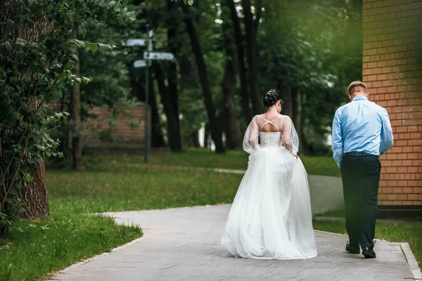 Novia y novio en la boda Día caminando al aire libre en la naturaleza de primavera. Pareja nupcial, feliz mujer recién casada y hombre abrazándose en el parque verde. Amar pareja de boda al aire libre. Novia y novio —  Fotos de Stock