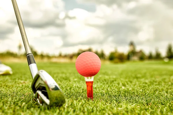 高尔夫球场上的洞上的球。 高尔夫概念。 高尔夫球击球前，将高尔夫球套在高尔夫球杆旁边的绿草上. — 图库照片