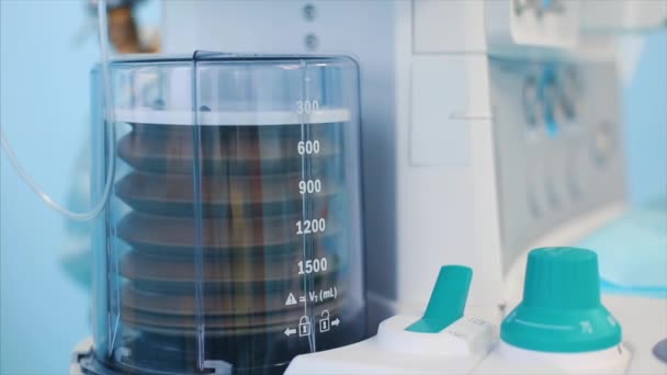 Vista de cerca del ventilador de la máquina de anestesia y el monitor de los pacientes dentro del quirófano. Primer plano, fondo borroso, luz azul . — Vídeo de stock