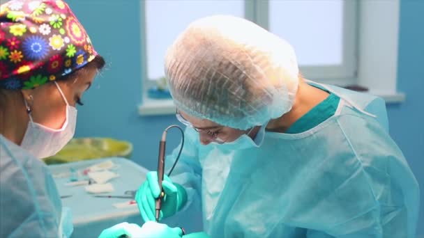 Een team chirurgen heeft een groot plan tijdens de operatie, een operatiekamer met blauw licht, een neuscorrectie om de esthetiek van de neus te verbeteren. Medetsina, plastische chirurgie. — Stockvideo