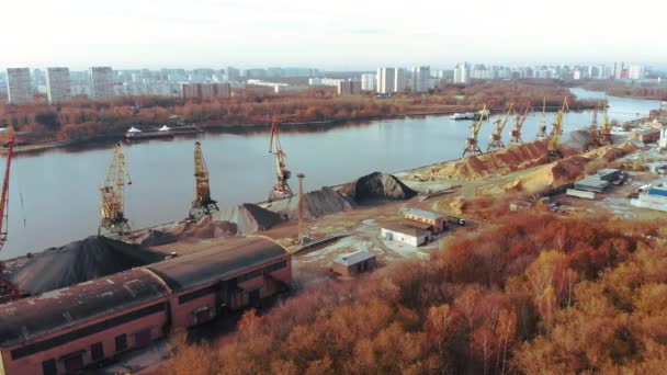 Port cranes on the river bank produce sand. Port cranes with a bucket on the river bank. Extraction of river sand. Port cargo cranes extracts river sand, production. Sunset. Barge. — Stock Video