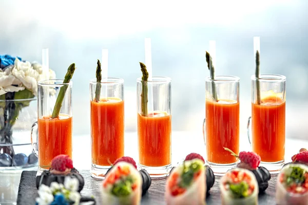 Zestaw koktajli z soku marchewkowego i szparagów. Zdrowe jedzenie migawki kilku marchewek i szparagów stojących na stole — Zdjęcie stockowe
