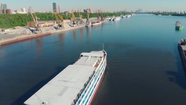 Prachtig landschap met een wit schip dat langs de rivierhaven vaart. Voorraadbeelden. Witte schip beweegt tegen grijze bewolkte lucht, rivier vervoer concept. — Stockvideo