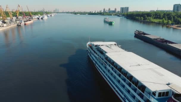 川の港に沿って航行する白い船と美しい風景。ストック映像だ灰色の曇りの空、川の交通の概念に対して移動する白い船. — ストック動画