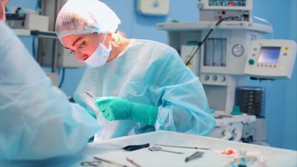 Un equipo médico de especialistas quirúrgicos que trabajan en el quirófano moderno del hospital, realizando la preparación del equipo del paciente para la cirugía . — Vídeo de stock