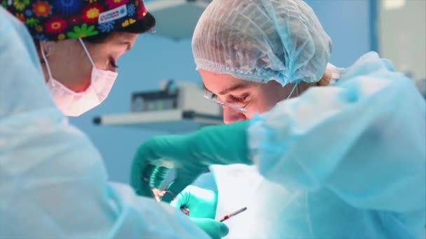 Uma equipe médica de especialistas cirúrgicos que trabalham na moderna sala de cirurgia do hospital, realizando a preparação da equipe do paciente para a cirurgia . — Vídeo de Stock