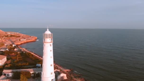 Leuchtturm auf dem Kap. Schöne Aufnahme aus der Luft, Flug über den Leuchtturm bei Sonnenuntergang, schönes Licht, malerische Landschaft Himmel und Meer, suristische Farben. Fliegen um den Leuchtturm — Stockvideo