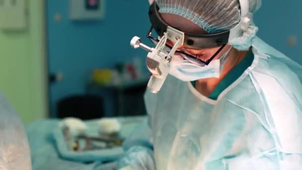 Uma equipe de cirurgiões tem um grande plano durante a cirurgia, uma sala de cirurgia de luz azul, uma cirurgia de rinoplastia para melhorar a estética do nariz. Medetsina, cirurgia plástica . — Vídeo de Stock