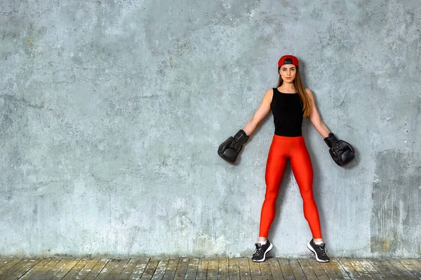 Menina atlética bonita posando em luvas de boxe rosa em um fundo cinza. Espaço para cópia. Conceito esporte, luta, meta de realização . — Fotografia de Stock