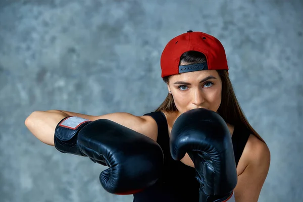 Menina atlética bonita posando em luvas de boxe rosa em um fundo cinza. Espaço para cópia. Conceito esporte, luta, meta de realização . — Fotografia de Stock